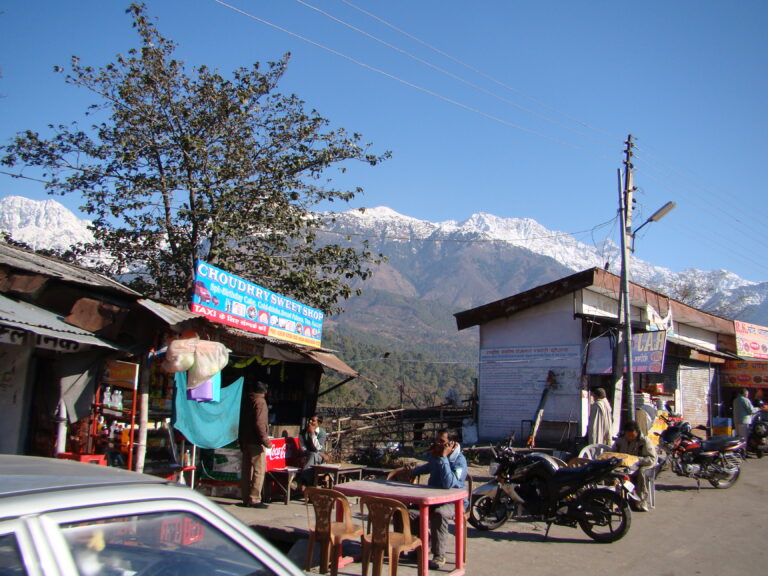 Small roadside sweet shop and cold drinks stall with snow-covered Himalayan mountains in the background