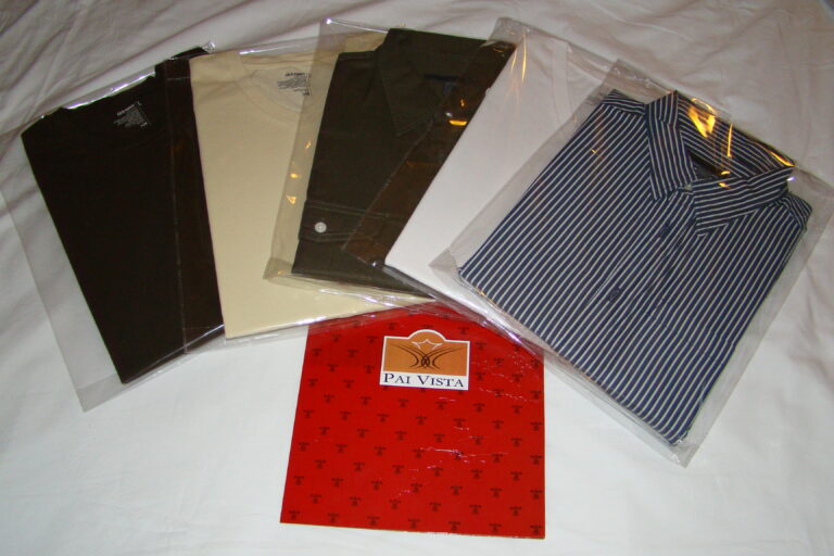 Freshly laundered shirts and trousers individually wrapped in plastic on a hotel bed at Pai Vista, Mysore
