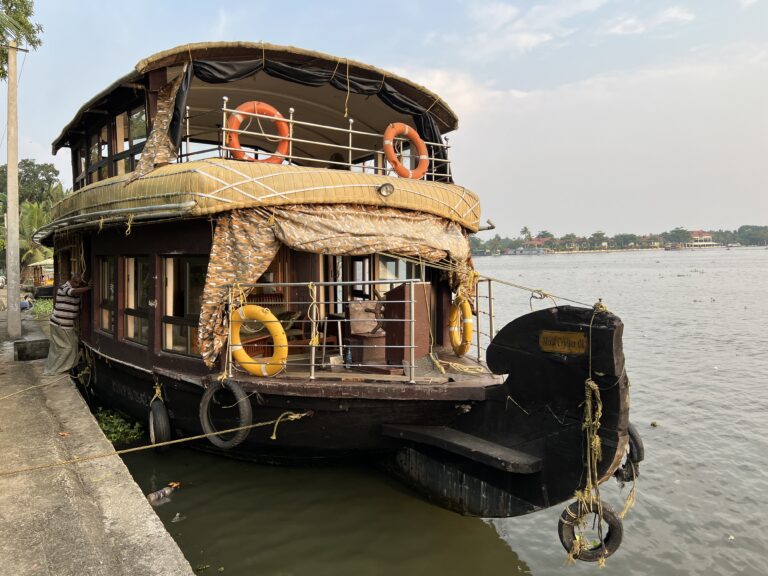 Traditional Kerala houseboat moored along the palm-lined backwaters in India